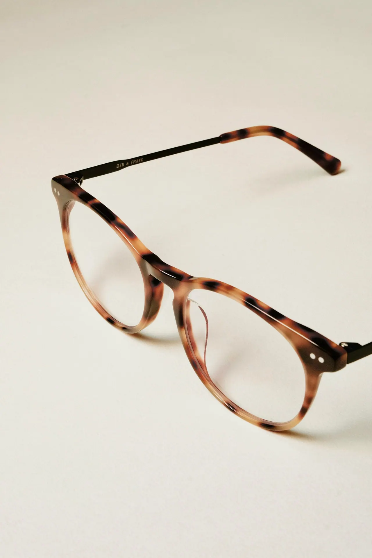 Round tortoiseshell glasses resting on a pale surface