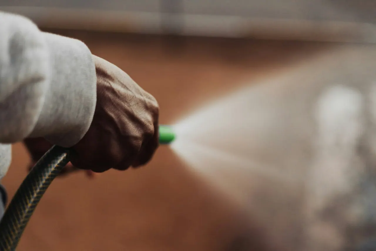 A close up of a fine spray nozzle in a gloved hand