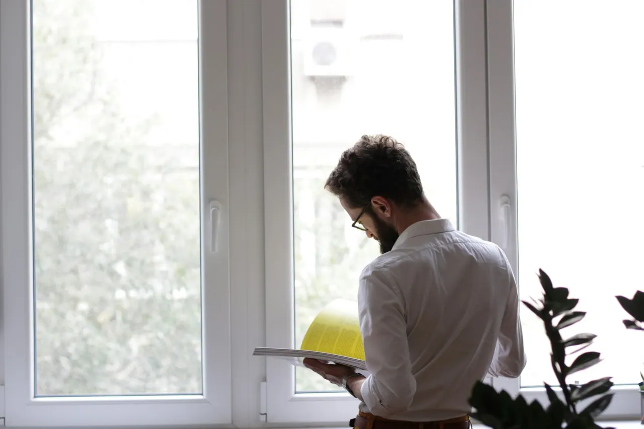 An inspector with a clipboard by a bright window
