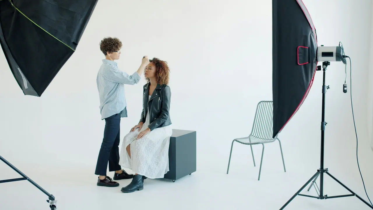 A makeup artist preparing a model on a studio set