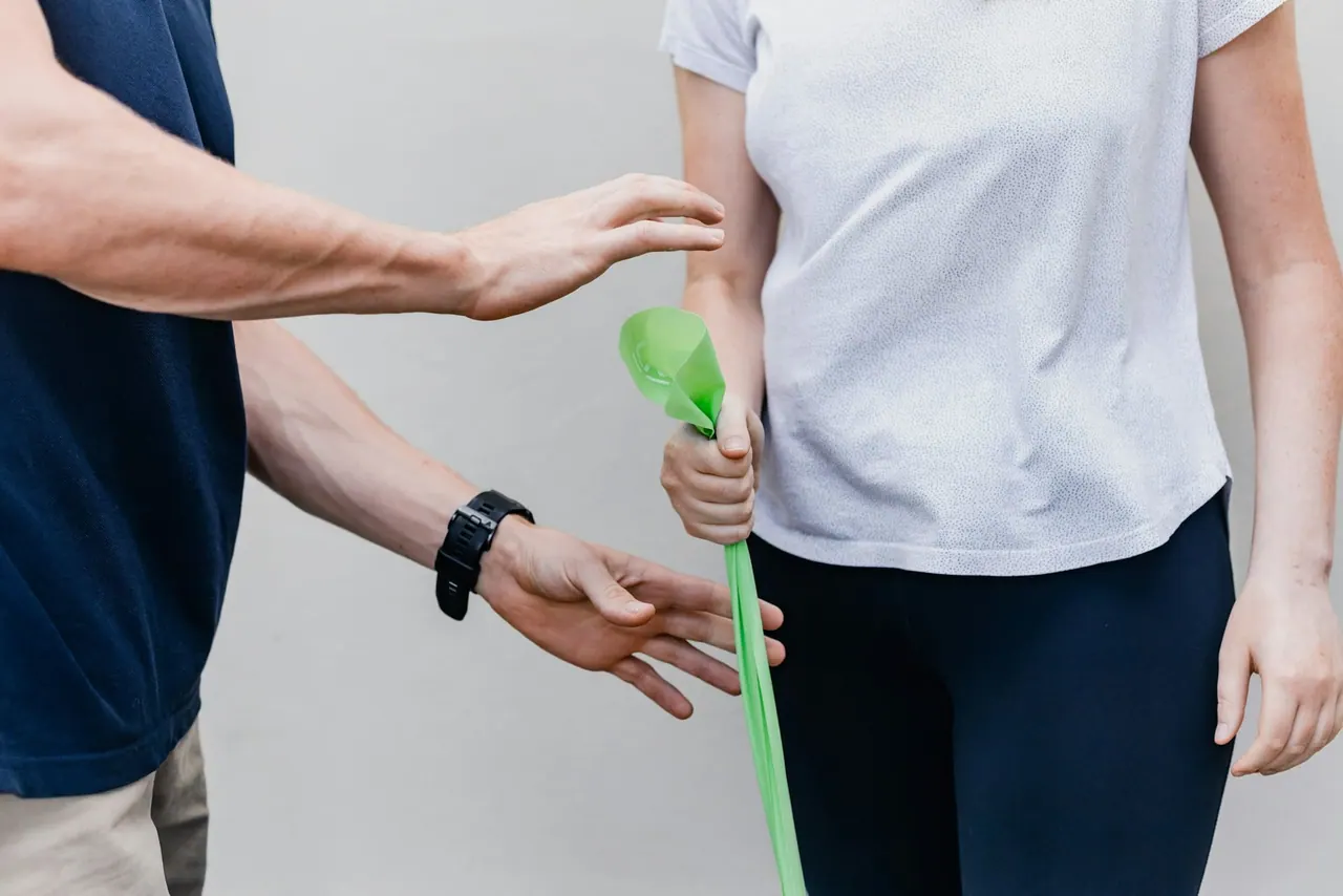 A physiotherapist guiding a resistance band exercise
