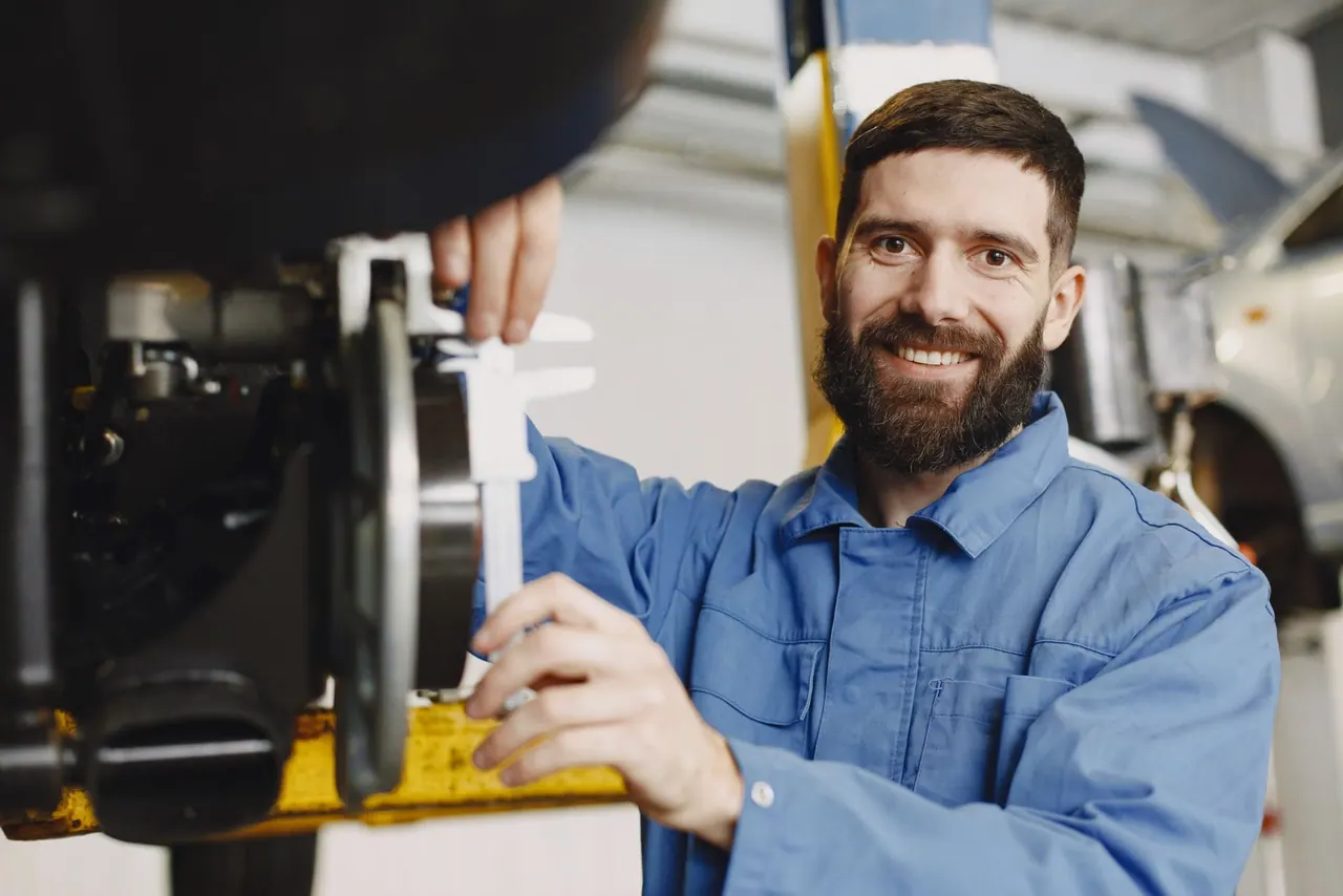 A smiling plumber at work in a blue work shirt
