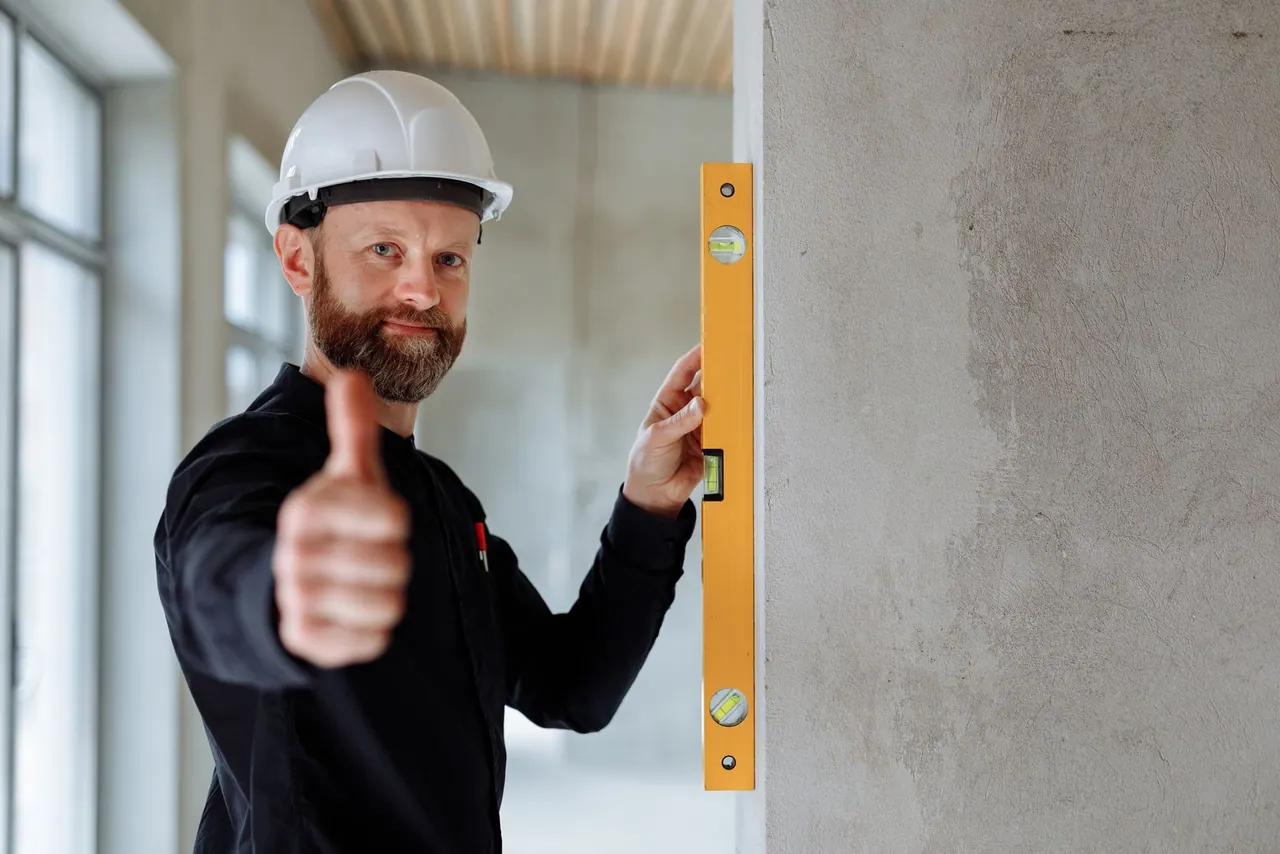 A friendly tradesman in a white hard hat giving a thumbs up