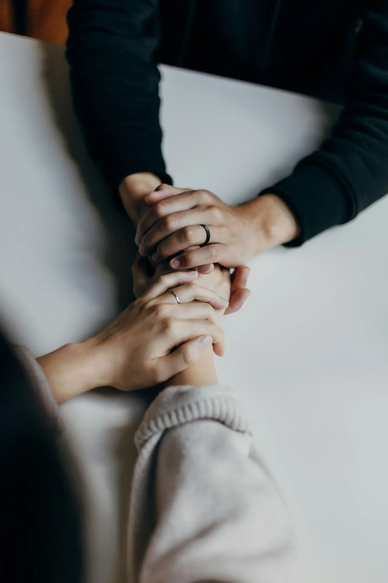 Two hands held gently across a table