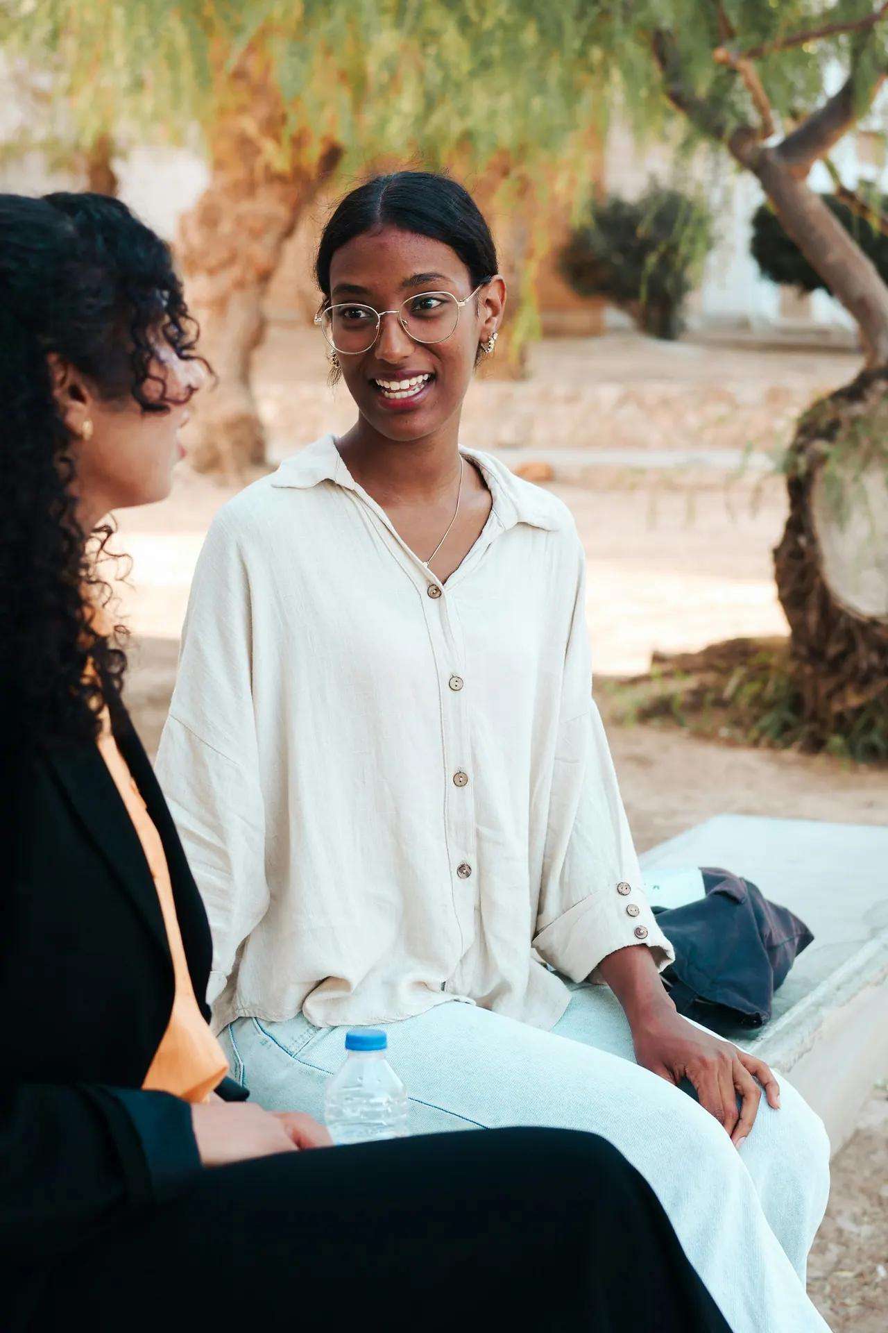 Two young women chatting and smiling outdoors