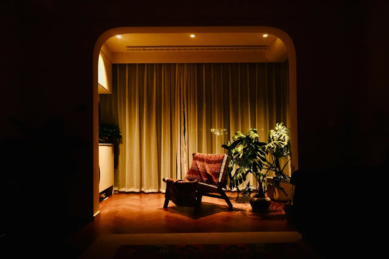 A warm lit corner with an armchair and a plant, ready for a session