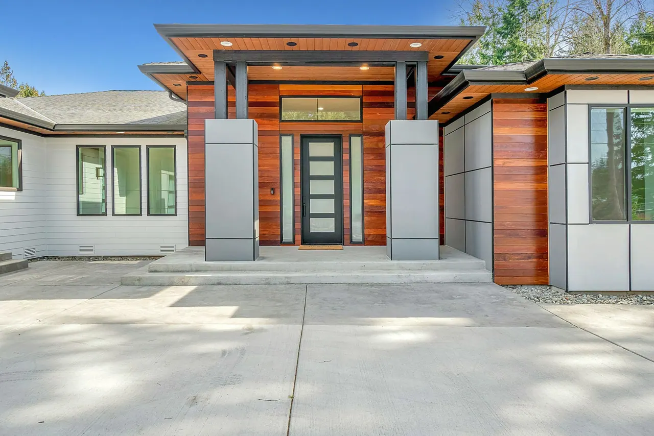A modern single storey home with a warm wood entrance, deep eaves and a wide driveway