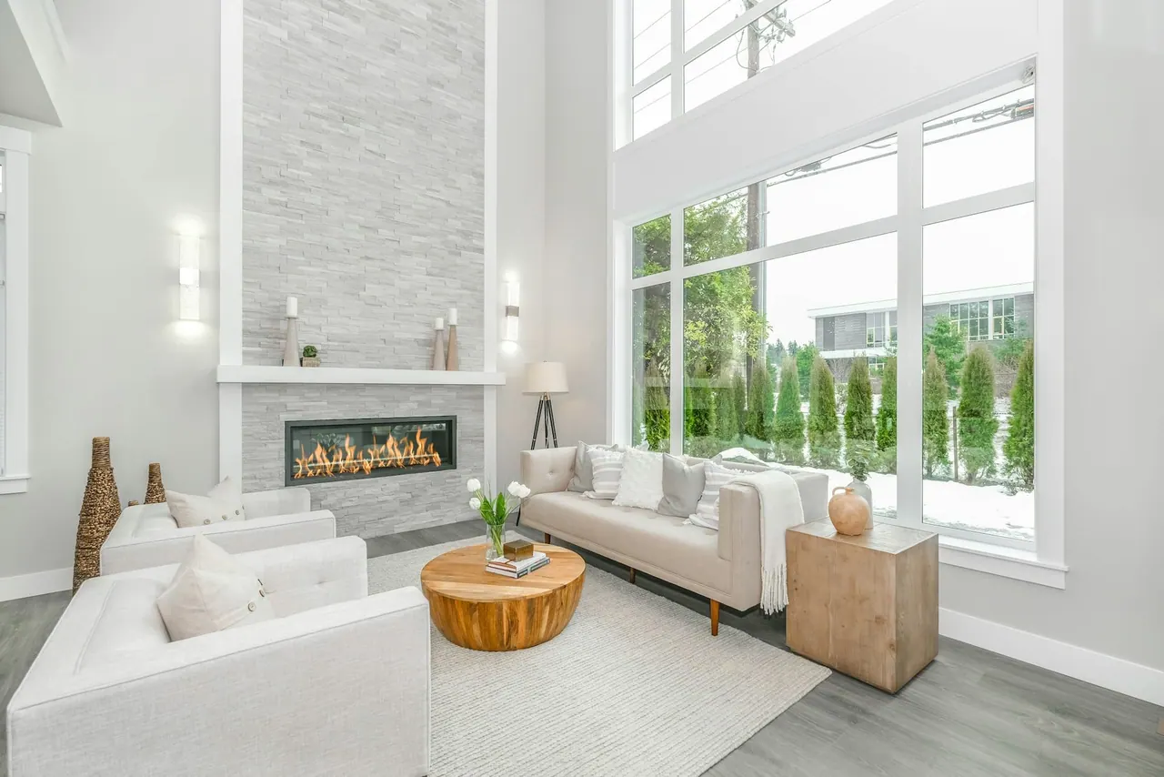 A bright living room with a white sofa beside a wall of glass