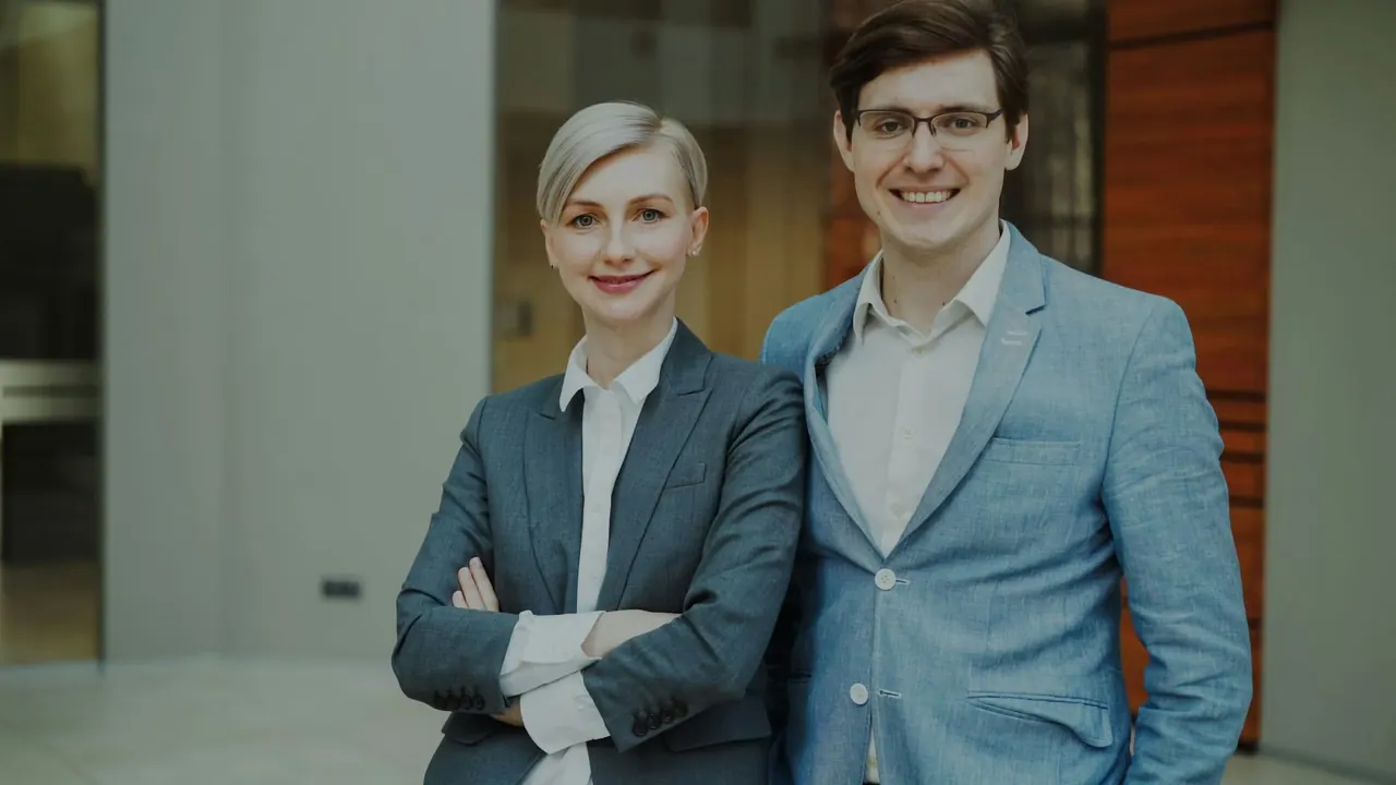 Two of our agents in suits, smiling in the office