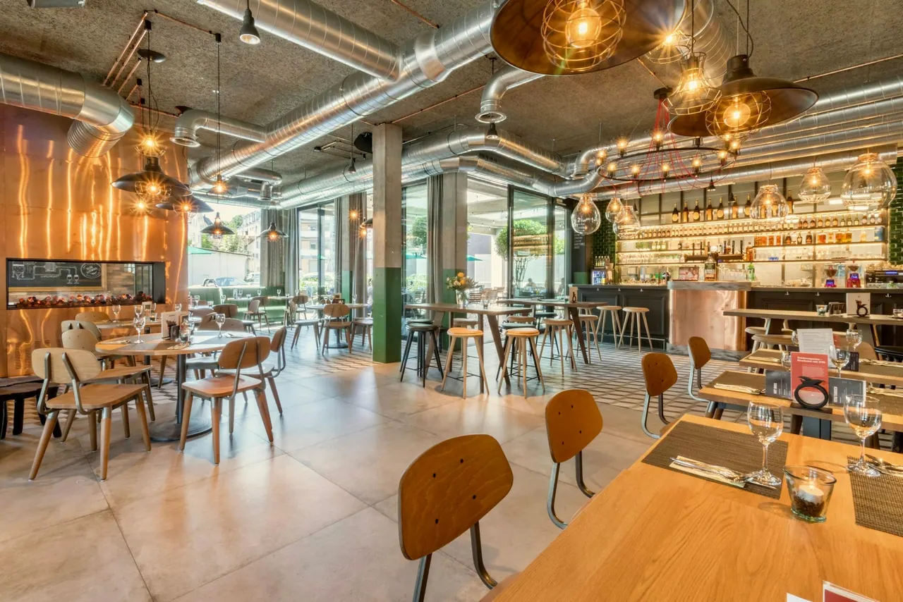 A sunny dining room with wooden tables and pendant lamps