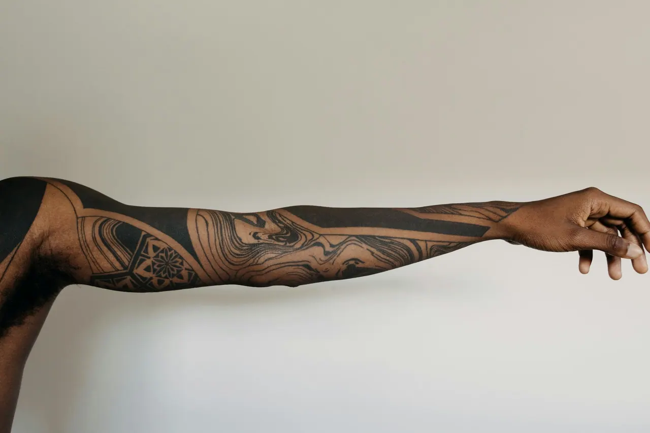 An outstretched arm with a full blackwork sleeve