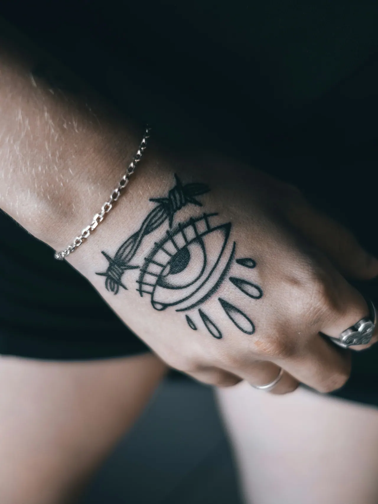 A bold eye tattoo on the back of a hand