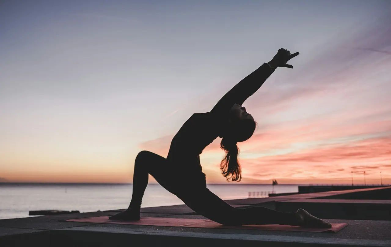 A low lunge silhouetted against a pink sunset sea